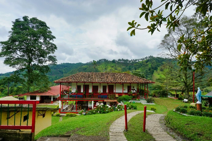 Traditional coffee farmhouse surrounded by green mountains in Colombia
