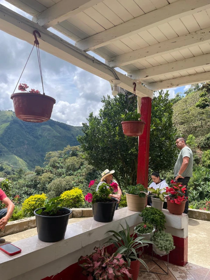 Farmhouse porch with hanging flower pots overlooking the Colombian coffee mountains